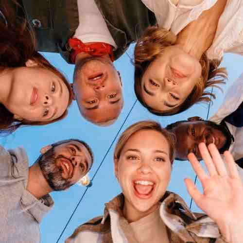 A group of friends waving at the camera.
